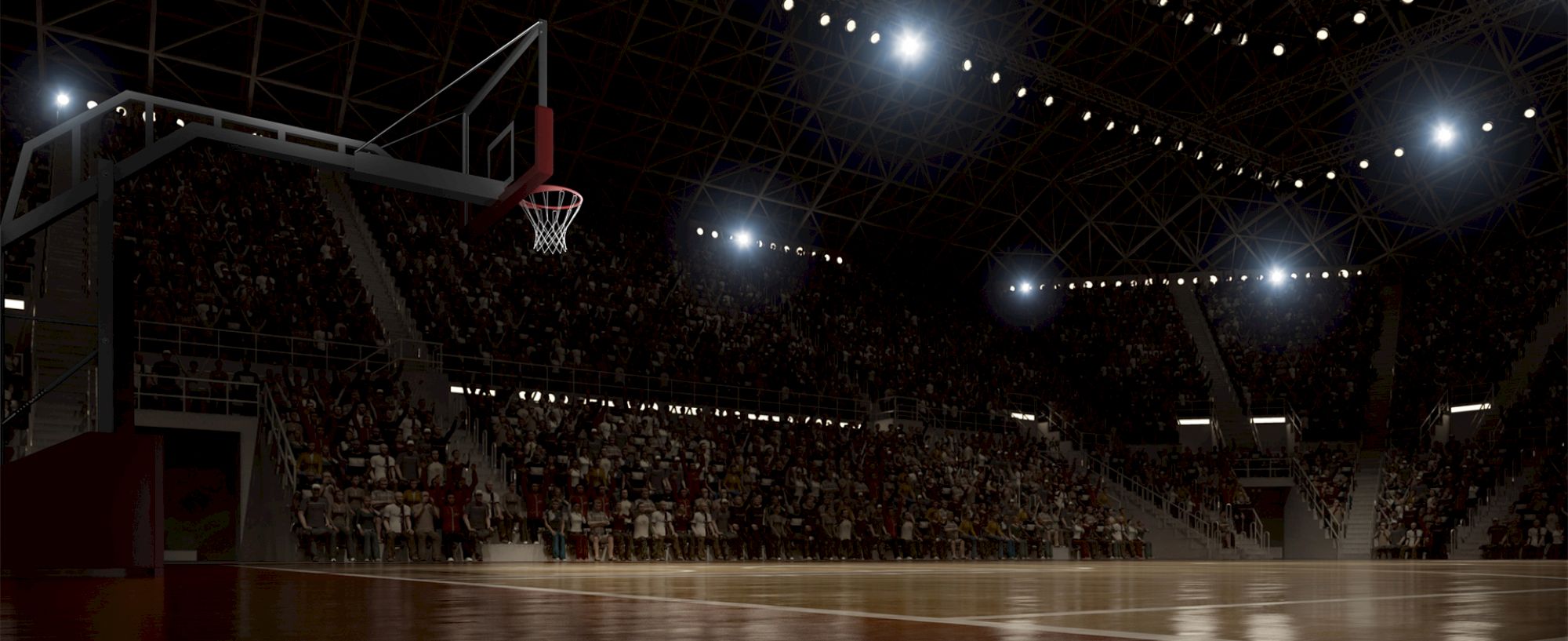 A dimly lit basketball arena with spectators in the stands during a game, focusing on the court and hoop under bright lights.